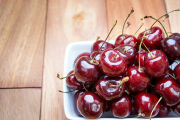 Fresh cherries in bowl on table