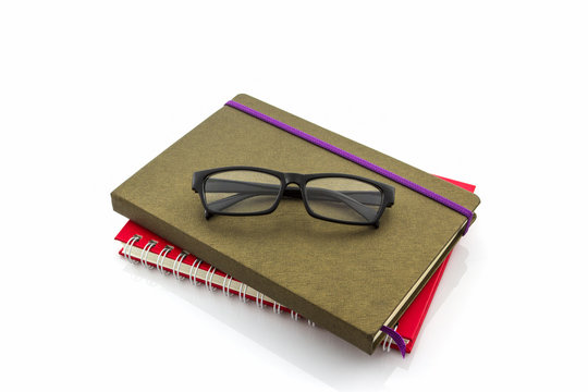 Red and brown book with glasses.