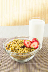 Cereal with strawberries and milk on the mat