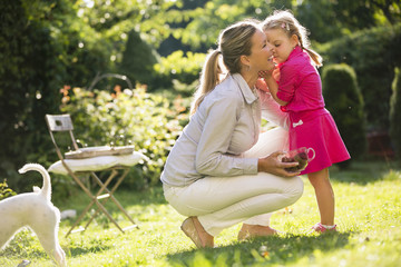 Mutter und Tochter im Garten kuscheln