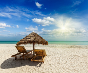 Two beach lounge chairs under tent