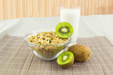 Cereal with milk and kiwi on a mat