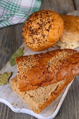 Fresh baked bread on cutting board, on wooden background