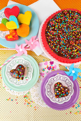 Delicious rainbow cakes on plates, on bright background