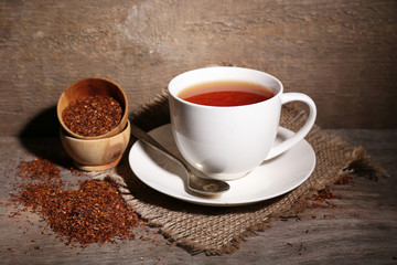 Obraz na płótnie Canvas Cup of tasty rooibos tea, on wooden table