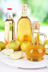 Apple cider vinegar in glass bottles and ripe fresh apples,