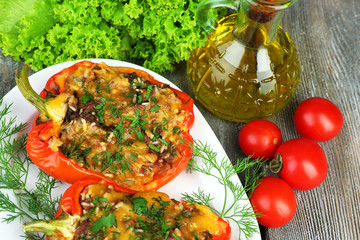 Stuffed red peppers with greens and vegetables on table close