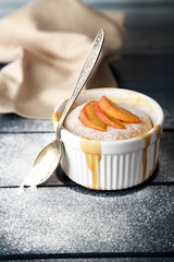 Tasty mini cake with fresh peach, on wooden table