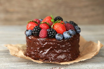 Tasty chocolate cake with different berries on wooden table