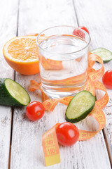 Glass of water with vegetables and measuring tape