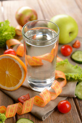 Glass of water with vegetables and measuring tape