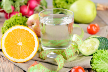 Glass of water with vegetables and measuring tape