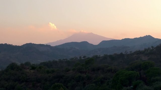 Smoke on the top of Mount Etna at evening twilight. Sicily