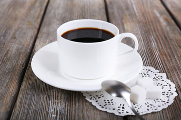 Cup of coffee on napkin on wooden background