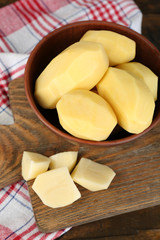 Raw peeled potatoes in bowl