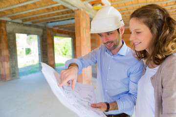 Young woman and architect on construction site
