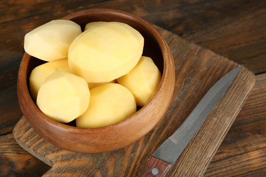 Raw peeled potatoes in bowl