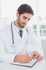 Fototapeta premium Doctor sitting and taking notes