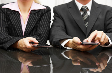 businessman and businesswoman using smart phone on meeting
