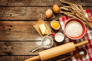 Fototapeta na wymiar Dough recipe ingredients on vintage rural wood kitchen table