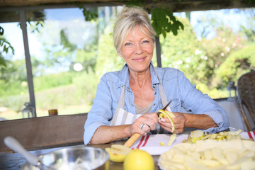 Senior woman cutting apples for pastry receipe