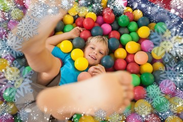 Fototapeta na wymiar Composite image of happy boy playing in ball pool