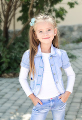 Obraz premium Portrait of adorable smiling little girl in the park