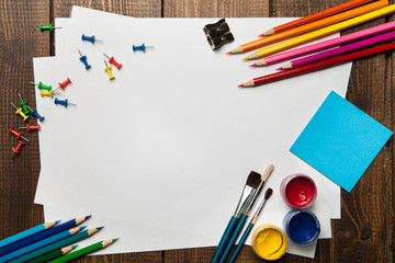School supplies with blank on wooden background