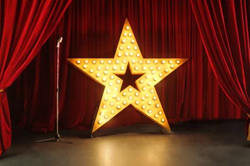 Selbstklebende Fototapete Theater Szene mit roten Vorhängen und großem Stern mit Lichtern