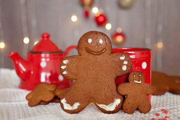 Smiling gingerbread man and a smaller one next to him standing i