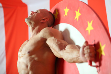 Bodybuilder standing raised his head up and straightened arms