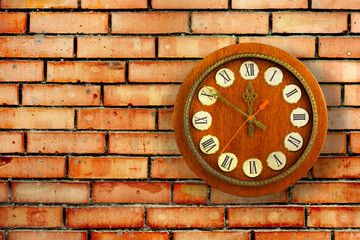 Old vintage clock on background of red brick wall