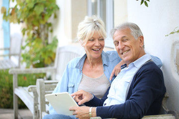 Fototapeta na wymiar Senior couple websurfing on internet with tablet