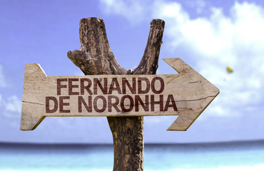 Fernando de Noronha wooden sign with a beach on background