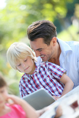 Portrait of man with son using digital tablet