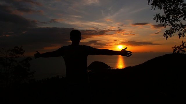 Man with Hands up at Sunset at the Top. Slow Motion.