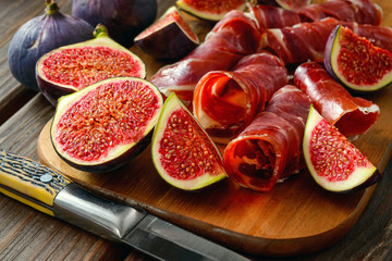 dried jamon slices with figs on wood table