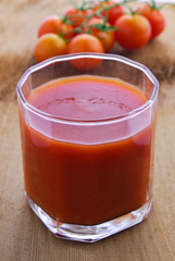 Tomato juice and  cherry tomatoes on the vine