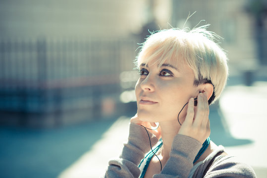 beautiful young blonde short hair hipster woman listening music