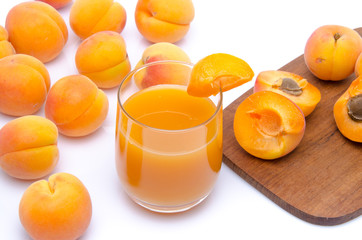 Glass of apricot juice with whole and sliced apricots