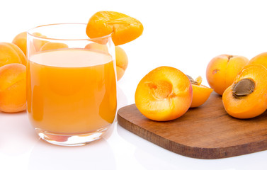 Glass of apricot juice with whole and sliced apricots