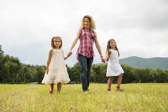 Mother playing outdoors with her daughters.