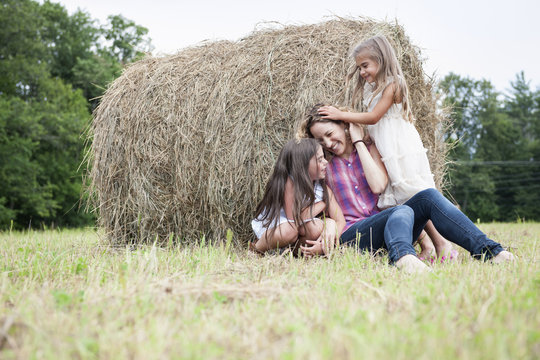 Mother playing outdoors with her daughters.