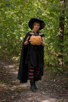 Halloween Witch with Pumpkin in the Forest