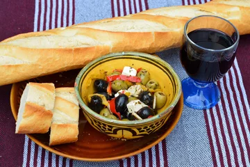 Foto auf Leinwand Eine Schüssel Oliven mit Baguette und Rotwein. © trinetuzun