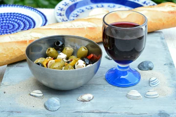 Fototapeten Een schaaltje olijven met stokbrood en rode wijn. © trinetuzun