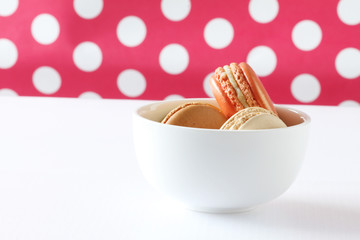 colourful french macaroons on polka dot background .