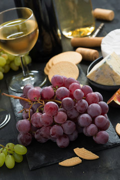 bunch of red grapes, assorted cheeses and appetizers, vertical