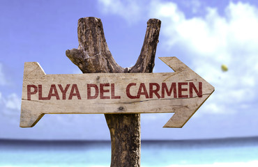 Playa del Carmen wooden sign with a beach on background