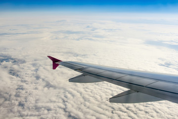 Obraz premium Fluffy clouds and airplane wing
